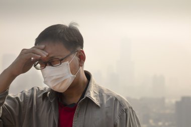 Hava kirliliğine karşı ağız maskesi giyen Asyalı adam
