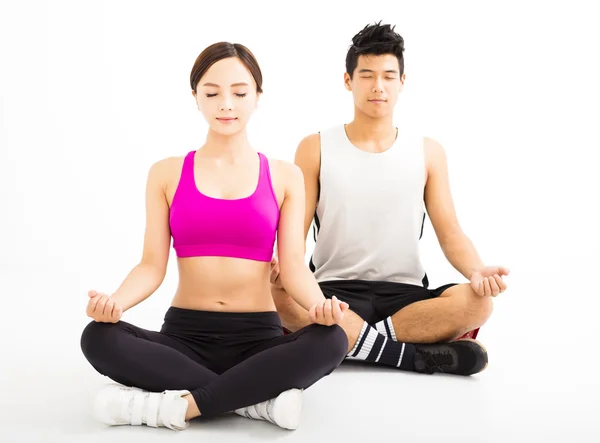 Pareja joven practicando yoga aislado sobre blanco —  Fotos de Stock