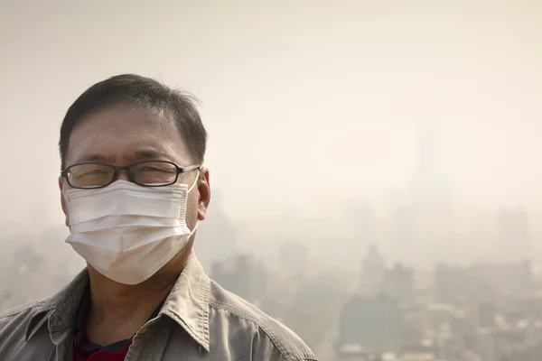 Ásia homem vestindo boca máscara contra ar poluição — Fotografia de Stock