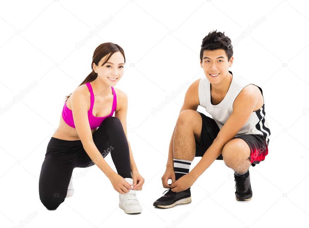 Woman and man tying sports shoes before workout