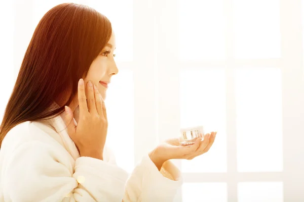 Mujer joven haciendo maquillaje delante del espejo del baño —  Fotos de Stock