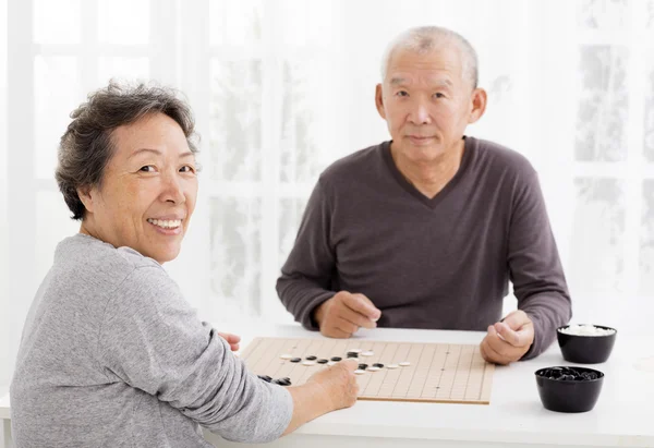 Happy asian senior couple playing chess in living room — Stock Photo, Image