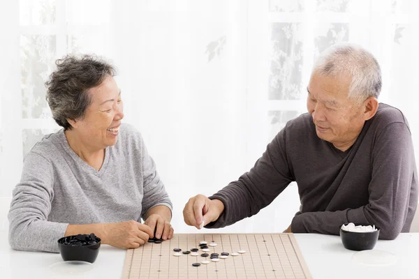 Happy asian senior couple playing chess in living room — Stock Photo, Image