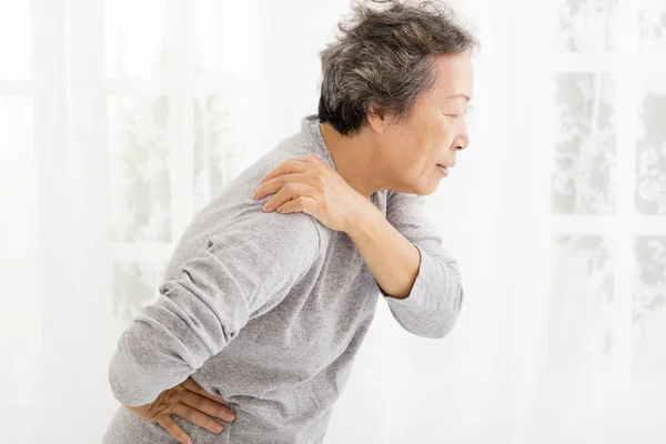 Пожилая женщина страдает от боли в плече — стоковое фото