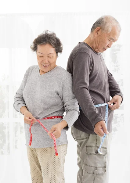 Asiático casal sênior medindo barriga com fita métrica — Fotografia de Stock