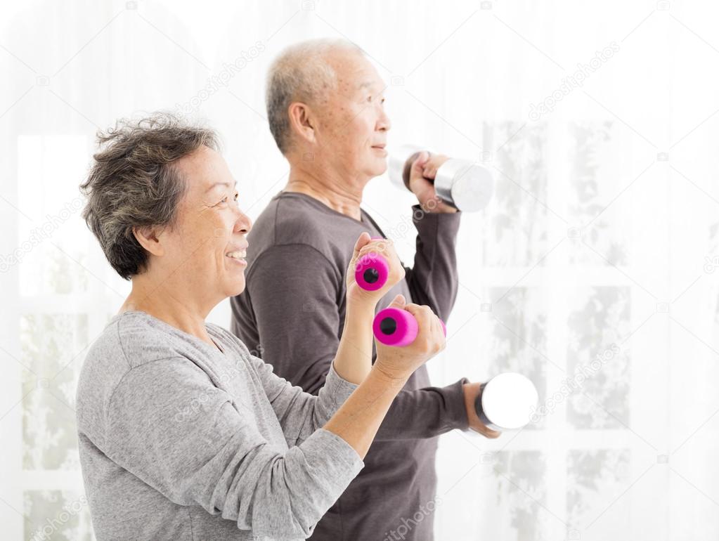 happy senior couple exercising with dumbbells 