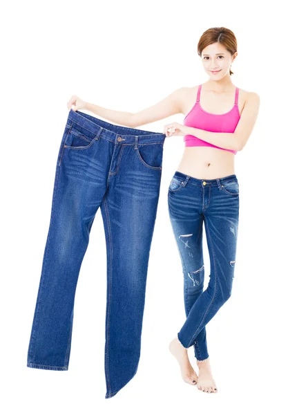 Happy beautiful slim young woman with big jeans — Stock Photo, Image