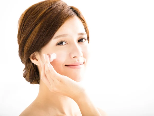 Smiling woman applying cream lotion on face — Stock Photo, Image