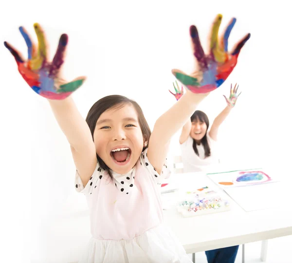 Glückliche kleine Mädchen mit Händen in der Farbe — Stockfoto