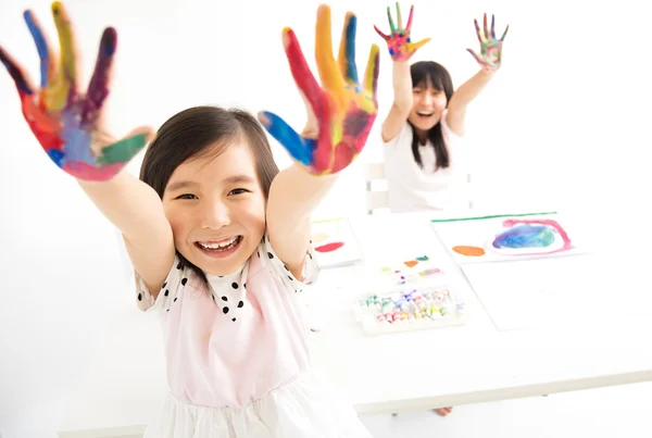 Glückliche kleine Mädchen mit Händen in der Farbe — Stockfoto