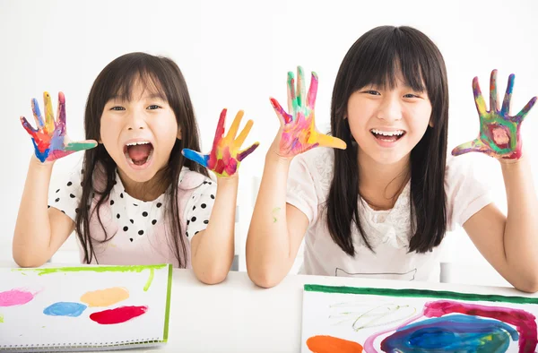 Glückliche kleine Mädchen mit Händen in der Farbe — Stockfoto