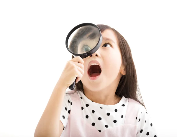 Little girl looking through a magnifying glass — Stock Photo, Image