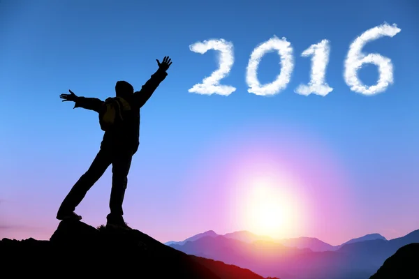 Счастливый новый 2016 год. Человек на вершине горы смотрит в облако — стоковое фото
