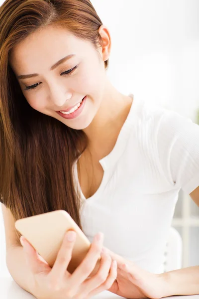 Joven hermosa mujer leyendo mensaje en el teléfono inteligente —  Fotos de Stock