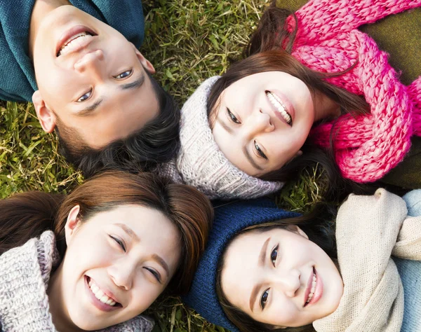 Szczęśliwy grupa młodych z zimowych nosić na trawie — Zdjęcie stockowe