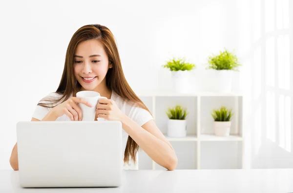 Jovem feliz com laptop na sala de estar — Fotografia de Stock