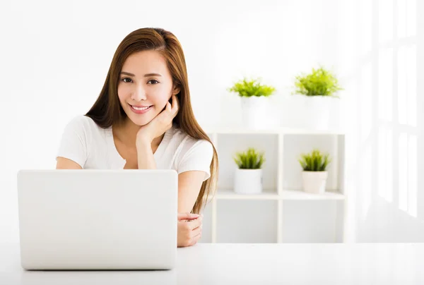 Szczęśliwa młoda kobieta z laptopa w salonie — Zdjęcie stockowe