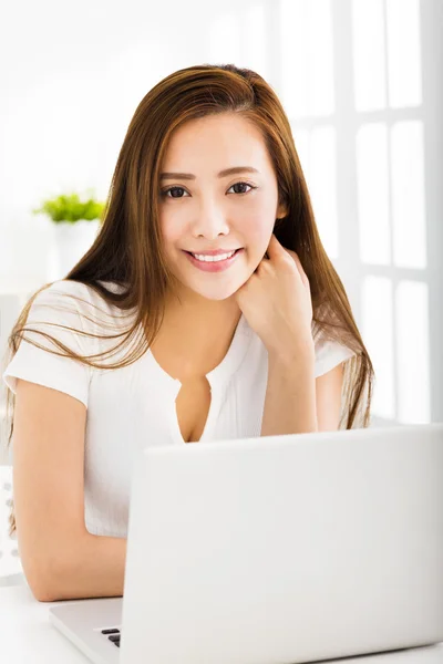 居間でノート パソコンを持つ幸せな若い女性 — ストック写真