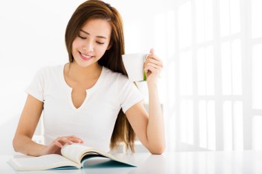 genç kadın oturma odasında bir kitap okuma