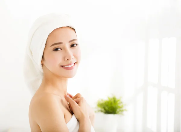 Usměvavá mladá žena s ručníkem na hlavě po koupeli — Stock fotografie