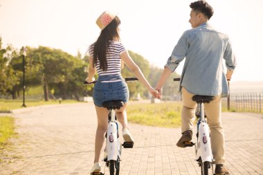 mutlu genç çift şehir parkı bisiklet sürme