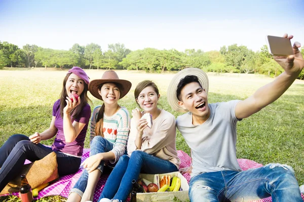 Feliz grupo joven haciendo selfie por teléfono inteligente —  Fotos de Stock