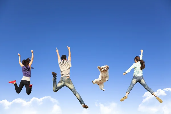 Grupo jovem feliz pulando junto com o cão — Fotografia de Stock