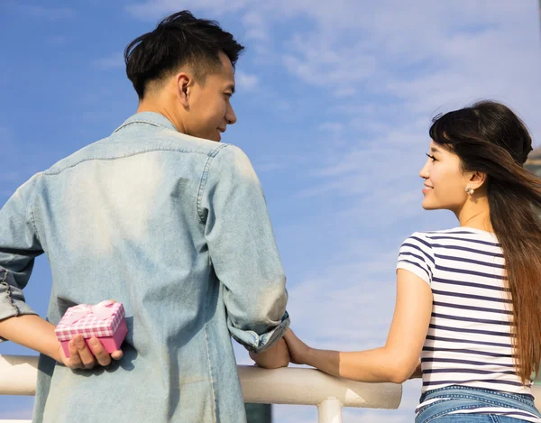 Happy young man gives a gift to  girlfriend — Stock Photo, Image