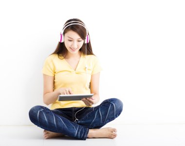Gülümseyen genç kadın tablet pc ile oturmuş