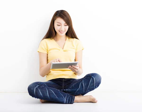 Lächelnd sitzende junge Frau mit Tablet-PC — Stockfoto