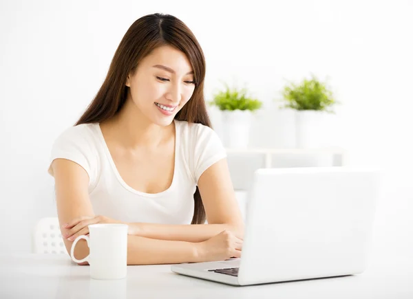 Mujer joven feliz con ordenador portátil en la sala de estar — Foto de Stock