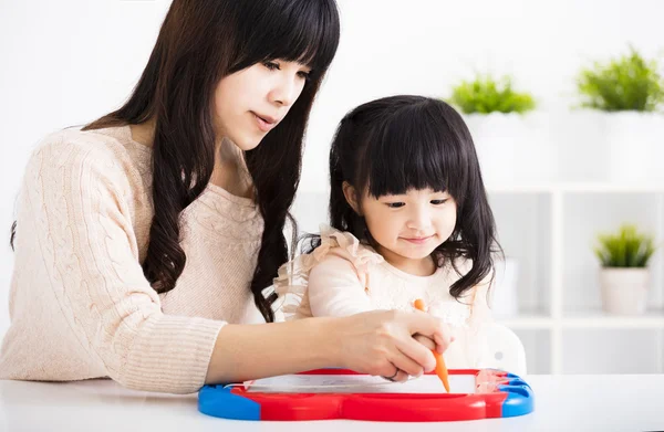 Mother or teacher helping child daughter to writing — Stock Photo, Image