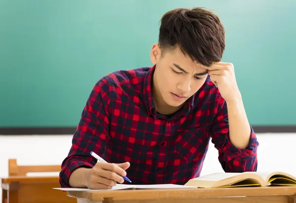 Estudante estressado estudando para exame em sala de aula — Fotografia de Stock