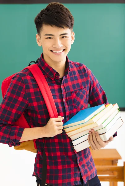 Sonriente estudiante masculino de pie en el aula —  Fotos de Stock