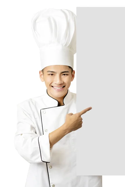 Young chef showing an empty board  isolated on white — Stock Photo, Image