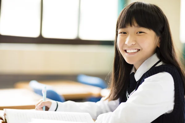 Glad söt student tjej med böcker i klassrummet — Stockfoto