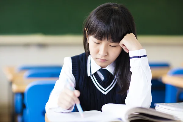 Gestresste Gymnasiastin sitzt im Klassenzimmer — Stockfoto