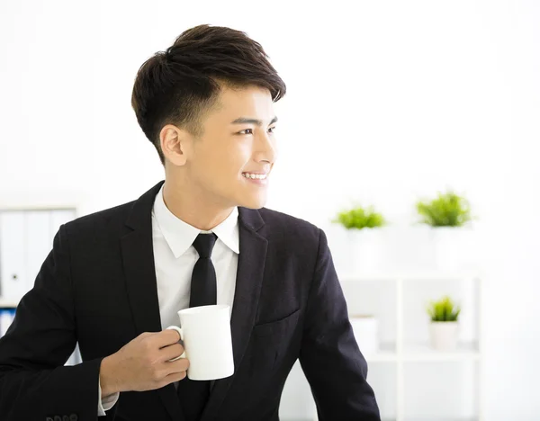 Glad ung affärsman avkopplande i office — Stockfoto