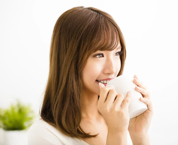 Mladá žena pít horké latte káva v obývacím pokoji — Stock fotografie
