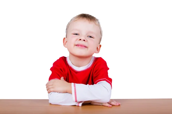 Petit garçon en T-shirt rouge, assis à la table — Photo