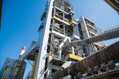 Çimento ve bina karışımı üretmek için ekin. Fabrika yapıları, mavi gökyüzüne karşı borular.