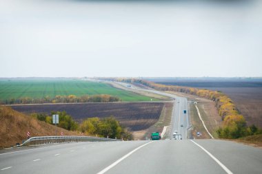 Trafiğin miktarı. Bulutlu sonbaharda şehirlerarası otoyol. Yol. Peyzaj