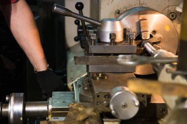 Metal işleme makinesi. Ağır bir sanayi işçisi çelik yapıların üretimi için bir makinede mekanik bir işlem gerçekleştiriyor.