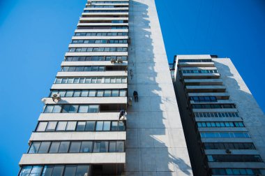 Tırmanışçılar binanın ön cephesinde inşaat ve montaj çalışmaları yapıyorlar.