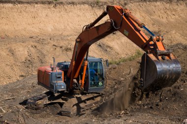 Sürücü kazıcının kovasını toprak işlerini yapmak için kullanır.