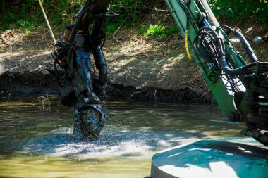 İşçiler, toprağı sudan kazmak gerektiğinde bir süzgeç kullanırlar.