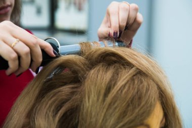 Güzellik salonu. Berber kuaförlük yapıyor. Berberin elleri kapalı.