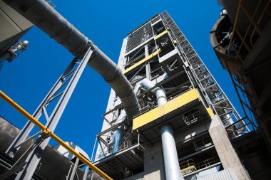 Çimento ve bina karışımı üretmek için ekin. Fabrika yapıları, mavi gökyüzüne karşı borular.