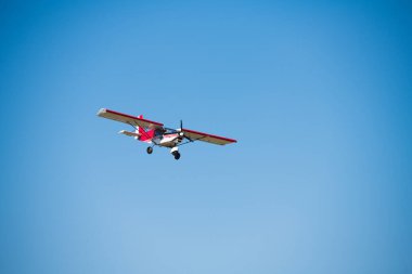Mavi gökyüzüne karşı küçük bir uçak. Bir tarım havacılık uçağının uçuşu