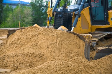 Eskisinin tamiri ve yeni bir asfalt yol inşaatı. Yeni yol inşaatında kazıcılar, grevciler ve yol silindirleri çalışıyor.